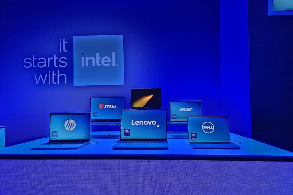 Six laptops sit on a tablet from various PC vendors, with an "It starts with Intel" sign above them.